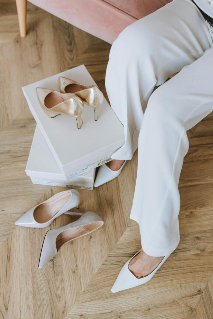 Close-up of a woman trying on elegant high heels indoors.